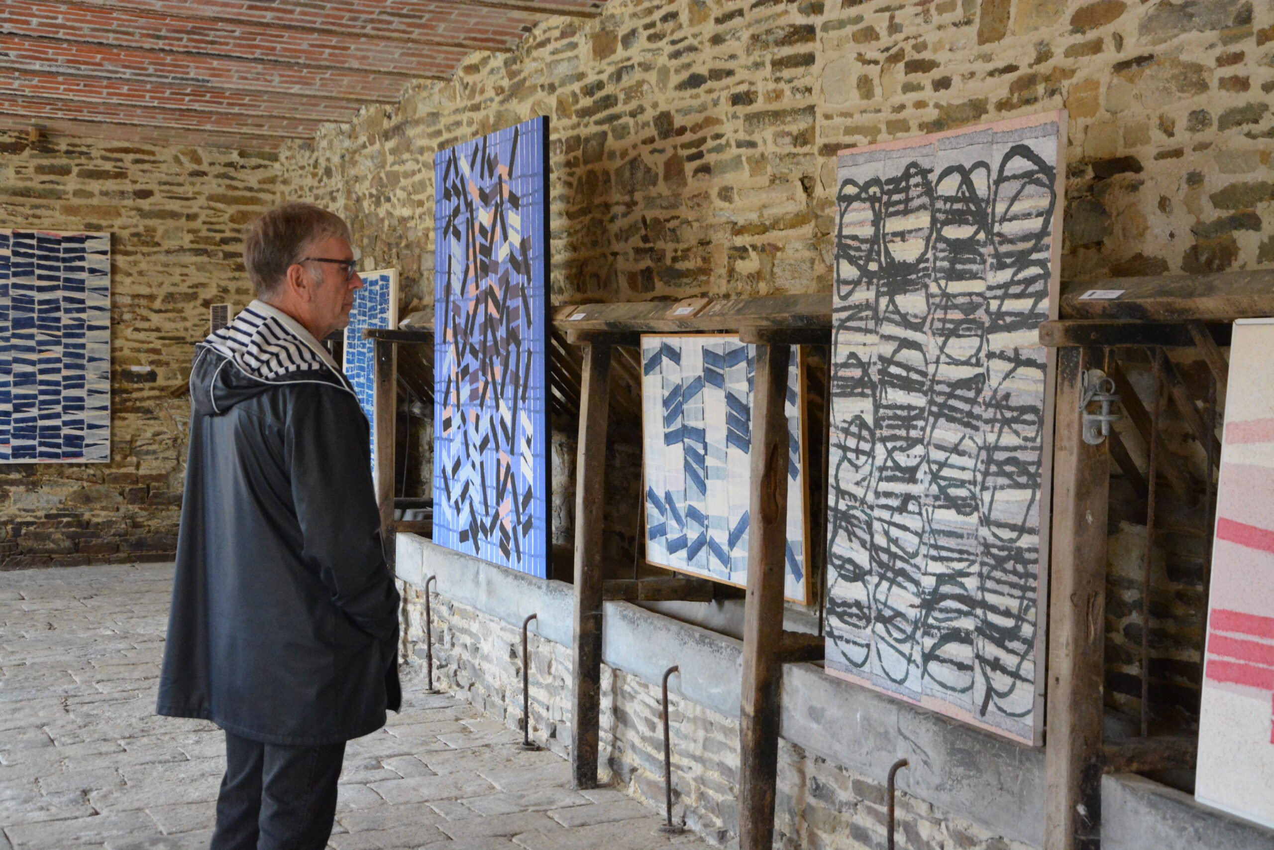 un homme contemple une œuvre exposée à Itinéraire, en quête d'artistes